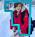 A child in a red coat staring through a large cutout of the Fort McMurray Wood Buffalo logo on a snowy day.